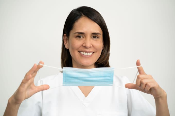 Zahnärztin hält eine Hygienemaske