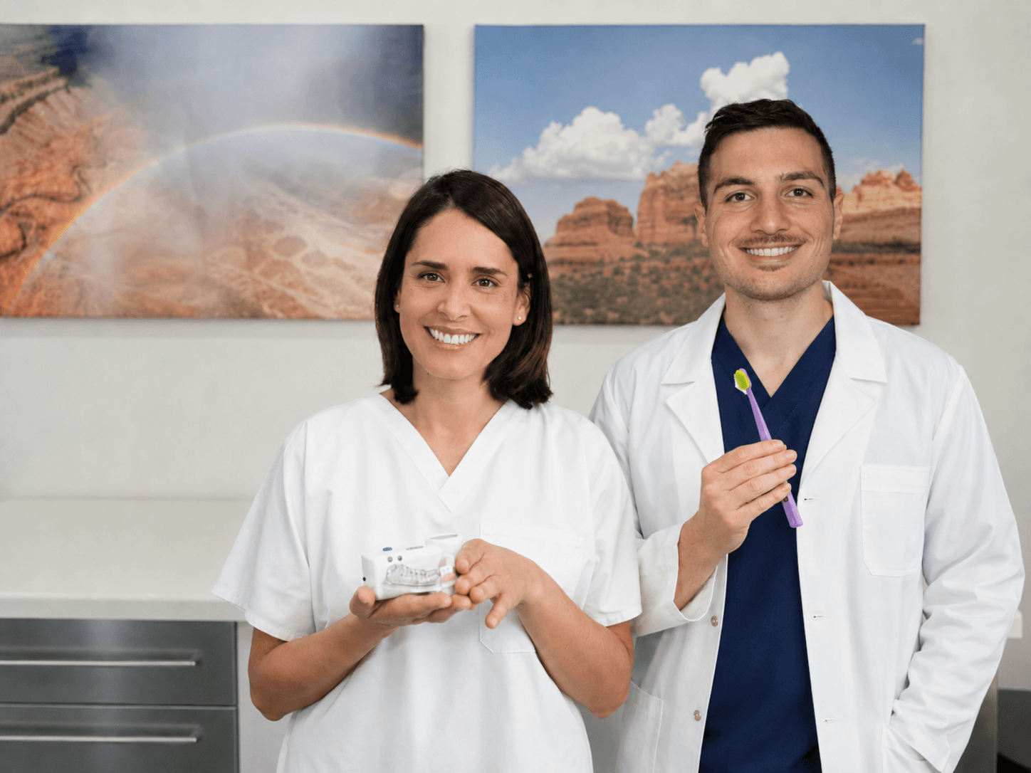 Zahnärztin Wanda Cespedes und ein Kollege aus dem Praxisteam mit Zahnmodell und Zahnbürste