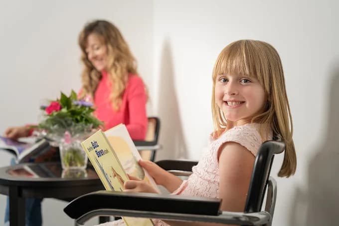 Kind liest ein Buch im Wartebereich